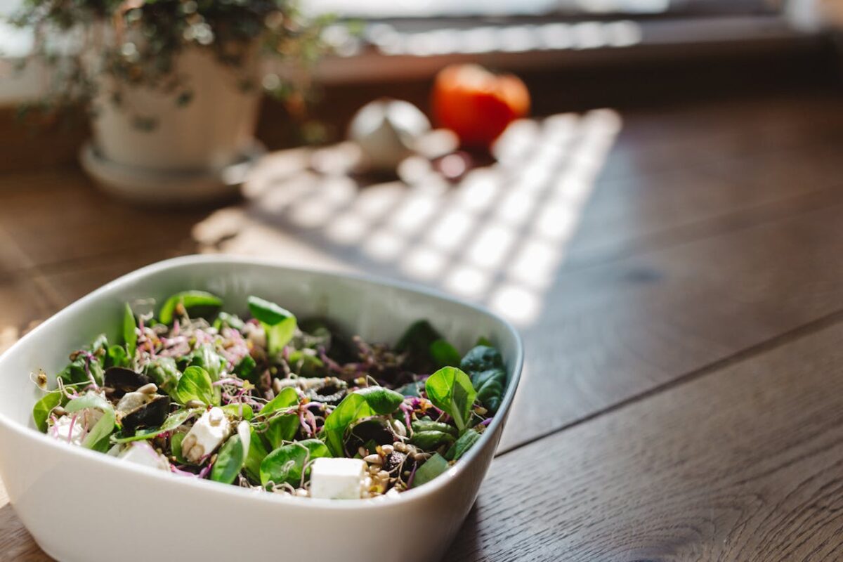 about-01 A vibrant and healthy bowl of tofu salad with fresh greens, captured in natural light on a wooden table.