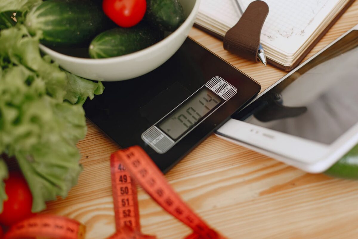 mission-img A bowl of fresh vegetables on a kitchen scale with measurement tools, depicting a healthy lifestyle.